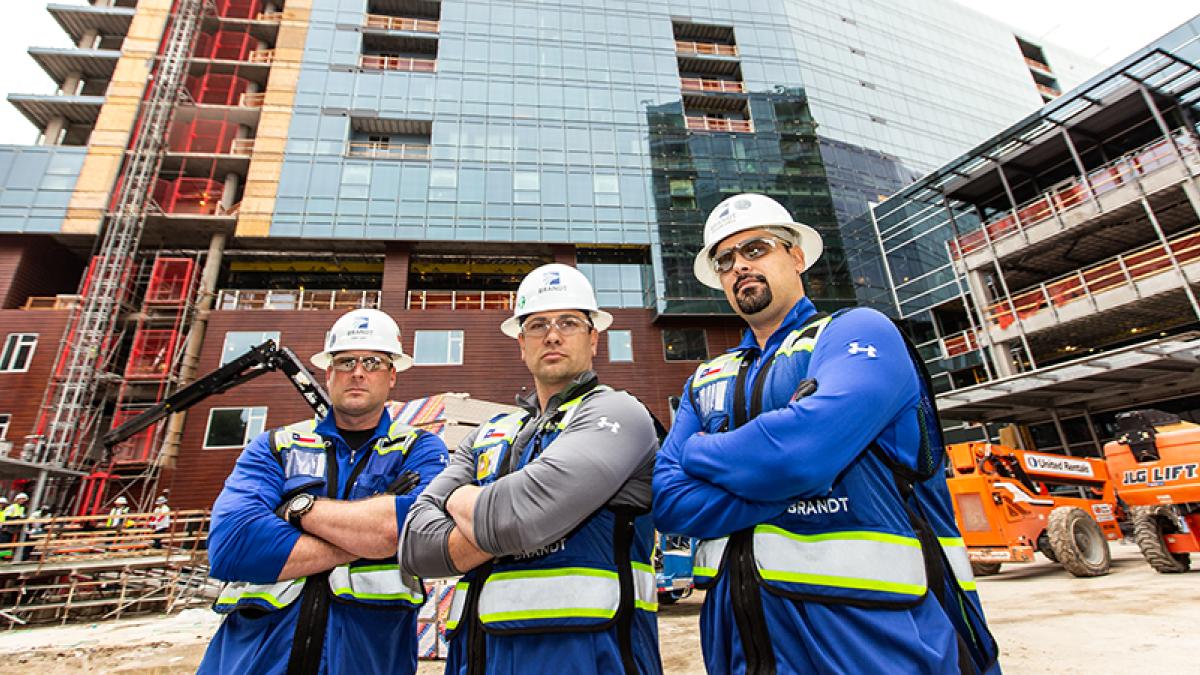 Three construction workers collaborating on a commercial construction project