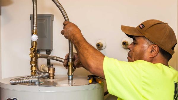 Plumber installs Tank Booster on hot water heater.