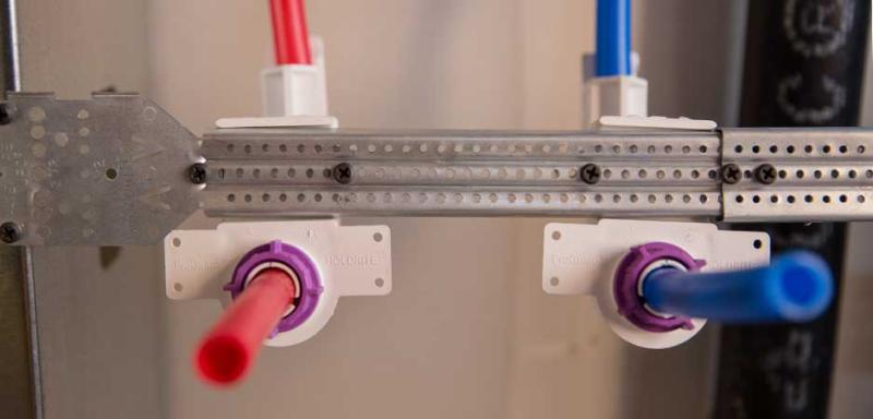 PEX plumbing pipes secured with HoldRite pipe support brackets inside a wall
