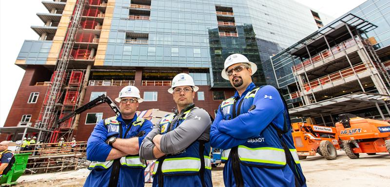 Three construction workers collaborating on a commercial construction project