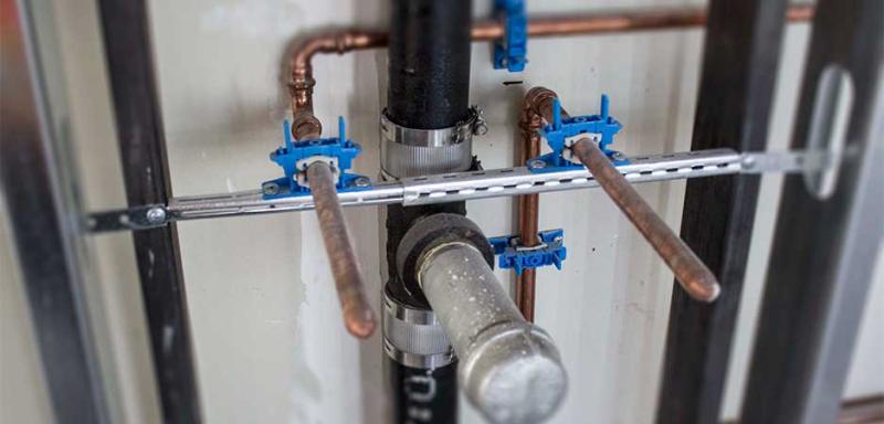 Comparison of makeshift plumbing support versus engineered pipe support solutions