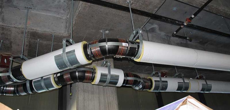 HoldRite no-hub fitting restraint securing cast iron pipe connections in plumbing system